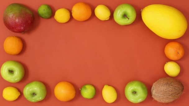 オレンジの背景にエキゾチックな果物で作られた熱帯夏のフレーム 動くな — ストック動画