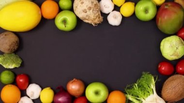 Siyah arka planda taze meyve ve sebzelerin taşınmasından oluşan canlı bir çerçeve. Hareketi durdur