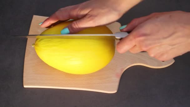 女性はまな板にナイフで新鮮な有機メロンを切断 — ストック動画