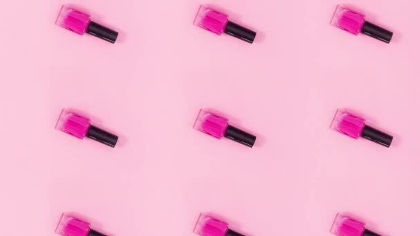 Лаки Ногтей Бутылки Вращаются Пастельно Розовом Фоне Стоп Движение — стоковое видео