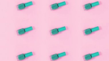 Tırnak cilası şişeleri pastel pembe arka planda döner. Hareketi durdur