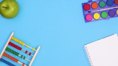 Okula geri dön. Stop motion. Okul aletleri mavi temanın üstünde ve altında sipariş veriyor. Hareketi durdur