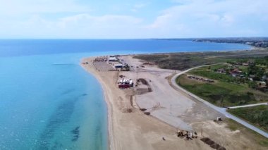 Plajı sahil barı ve turistlere hazırlamak için sıkı çalışan Long Sandy Plajı. Hava görünümü 