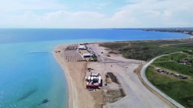 Plajı sahil barı ve turistlere hazırlamak için sıkı çalışan Long Sandy Plajı. Hava görünümü 