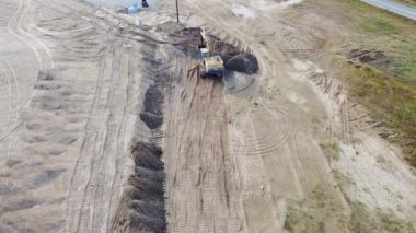 Kazı makinesi kumlu sahilde çalışıyor. Hava görünümü 