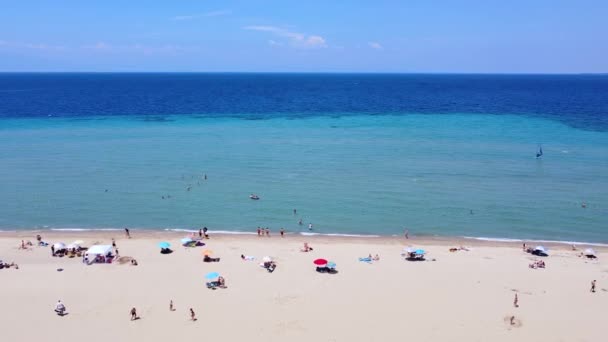 해변의 모래사장 과푸른 바다에 사람들은 주말을 보낸다 공중에서 — 비디오