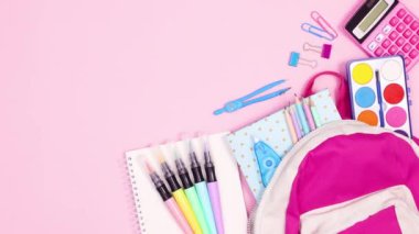 Okul kırtasiyesini pembe temalı sırt çantasıyla taşımak. Hareketi durdur