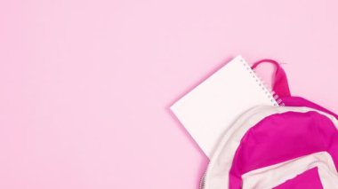 Okul gereçleri pembe temalı sırt çantasından çıkıyor. Hareketi durdur