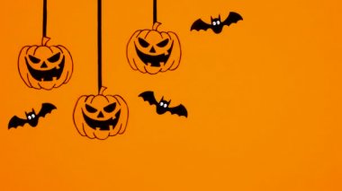 Cadılar Bayramı uçan yarasaları ve turuncu temalı halat üzerinde balkabaklarını oynatmak. Hareketi durdur