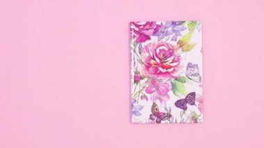 Pastel pembe temada güzel bir çiçek defteri belirir ve açılır. Hareketi durdur