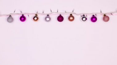 Noel çelenginde yanıp sönen ışıklar ve kurdeleye asılı pembe gümüş toplar. Hareketi durdur