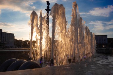 Güneşli bir yaz gününde gün batımında çeşmenin fıskiyeleri