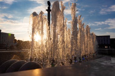 Güneşli bir yaz gününde gün batımında çeşmenin fıskiyeleri