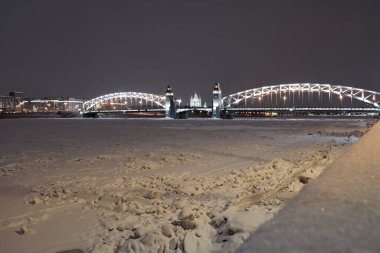 Buzun altındaki nehir üzerindeki köprü gece aydınlandı.