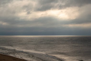 Yaz denizi gün batımında Bulutlu bir gökyüzüne karşı, curonian tükürüğü