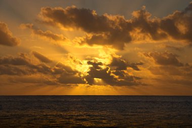 Güzel günbatımı gökyüzü denizin üzerinde. Güneş ışınları bulutlara doğru ilerler.