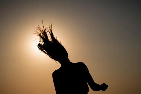 Tramonto e silhouette di un'adolescente in movimento — Foto Stock