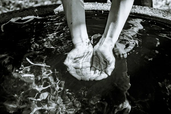 Holding water from a well  in cupped hands, black and white shot — Stock Photo, Image