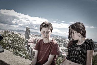 arka planda Barcelona ile bir duvara oturan kardeşler