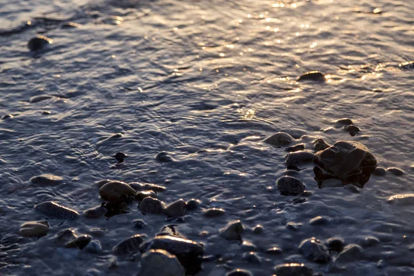 Feuchte Kieselsteine beim Sonnenuntergang für Hintergründe — Stockfoto