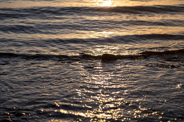 Ozean plätschert bei Sonnenuntergang nach Hintergründen — Stockfoto