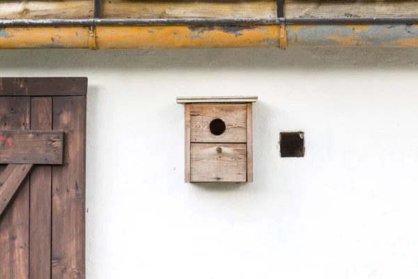 Vieja caja de nido simple en una pared blanca — Foto de Stock