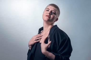 studio shot of a young, strong, beautiful woman with very short blond hair