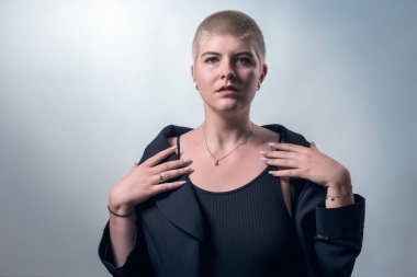studio shot of a young, strong, beautiful woman with very short blond hair