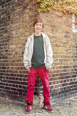 genç çocuk yaşlı bir tuğla duvar önünde portresi
