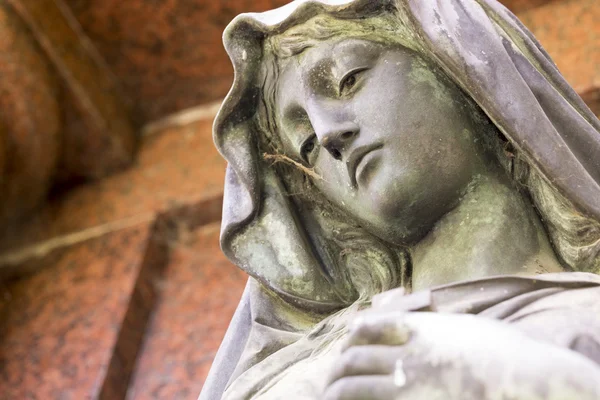 Bronze sculpture of maria with red background — Stock Photo, Image