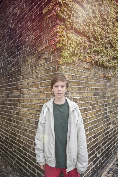 Portrait of a teenager boy in front of an old brick wall — Stock Photo, Image