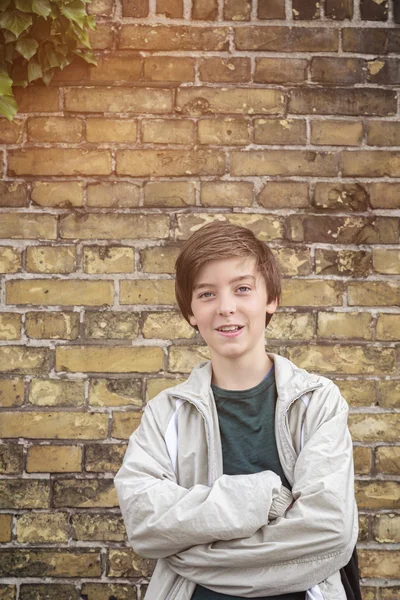 Porträtt av en leende tonåring pojke med korsade armar — Stockfoto