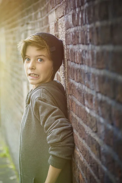 Doodsbang tiener jongen leunend op een muur — Stockfoto