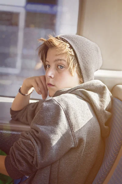 Πορτρέτο ενός έφηβου αγοριού με Τόκα, που κάθεται σε ένα λεωφορείο — Φωτογραφία Αρχείου