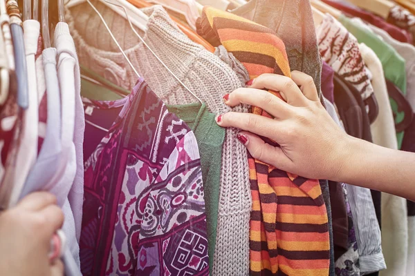 Close up van een hand, op zoek op een rommelmarkt voor kleding — Stockfoto