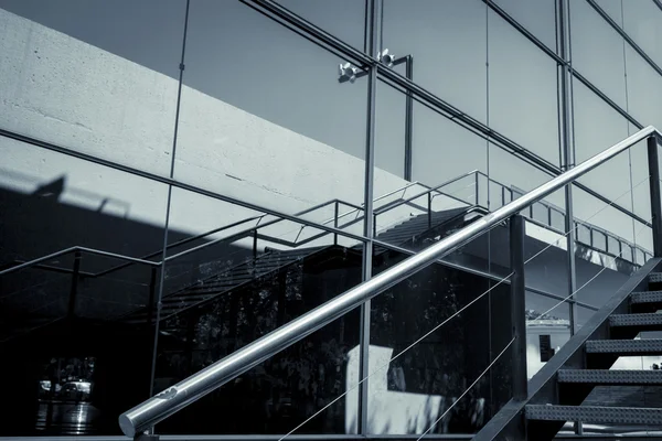 Detail of a glass facade with reflection and handrail — Stock Photo, Image