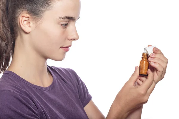 Woman is examine a bottle of homeopathic medicine, isolated on w — Stock Photo, Image