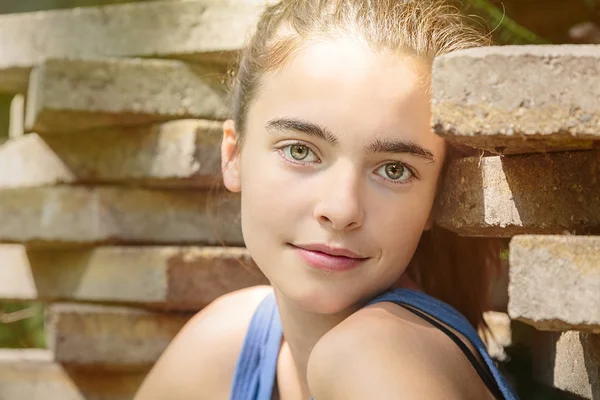 Retrato de una adolescente apoyada en una pila de losas — Foto de Stock