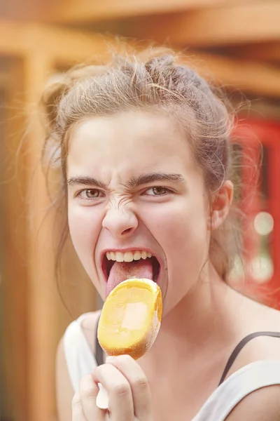 Portrait of an eager teenage girl eating popsicle — Stock Photo, Image