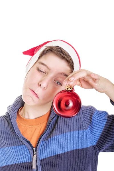 Lustiger Junge schaut auf eine rote Weihnachtskugel, isoliert auf weiß — Stockfoto