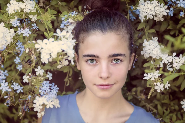 Retrato de uma bela adolescente em um arbusto florescendo — Fotografia de Stock