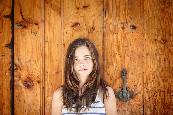 Retrato de uma bela adolescente na frente de uma madeira antiga — Fotografia de Stock