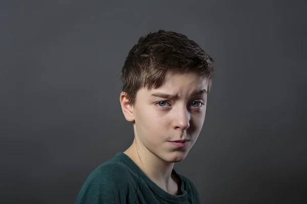 Retrato de un adolescente dudoso con fondo gris para rápido —  Fotos de Stock