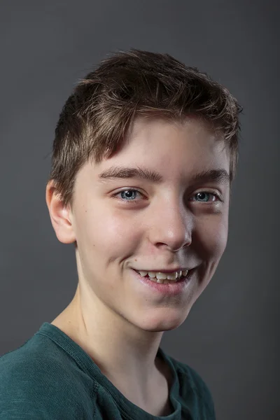 Retrato de um adolescente sorridente, com fundo cinza para rápido — Fotografia de Stock