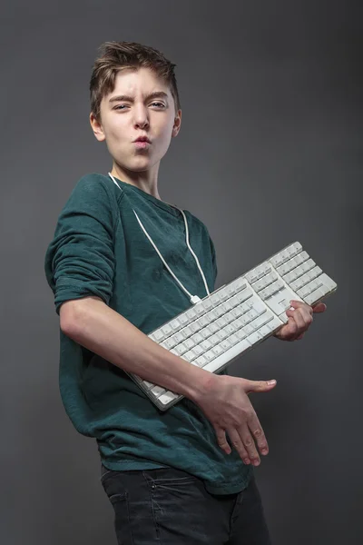 Teenage boy using a computer keyboard like a guitar, isolated on — Stock Photo, Image