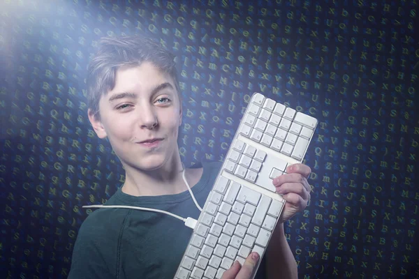 Menino adolescente sorridente com teclado de computador e salada de letras como — Fotografia de Stock