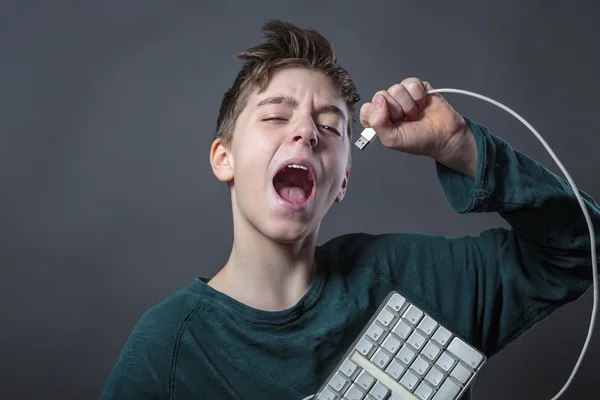 Cantando adolescente con teclado de computadora y fondo gris f —  Fotos de Stock