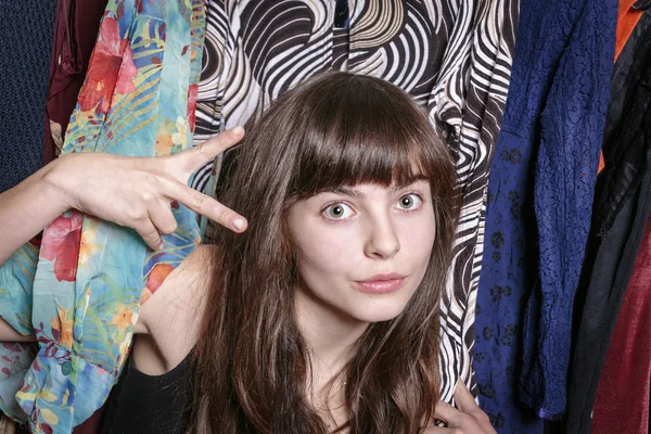 Adolescente con su armario mostrando una tijera con una mano Fotos de stock libres de derechos