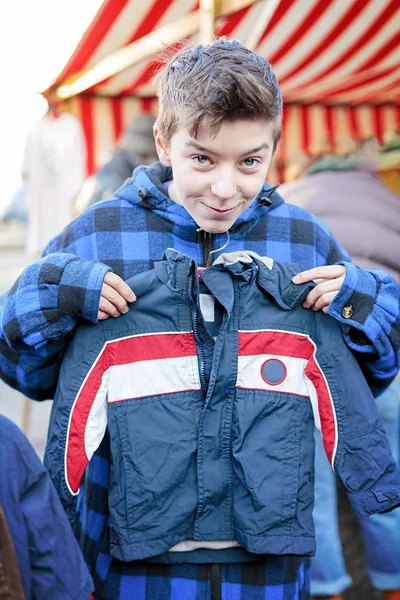 Legrační dospívající chlapec na bleší trh se snaží příliš malé šaty — Stock fotografie