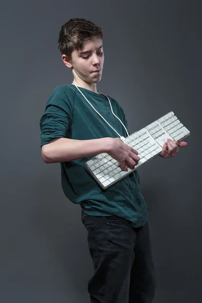 Genç çocuk bir piyano gibi bir bilgisayar klavye kullanarak izole — Stok fotoğraf